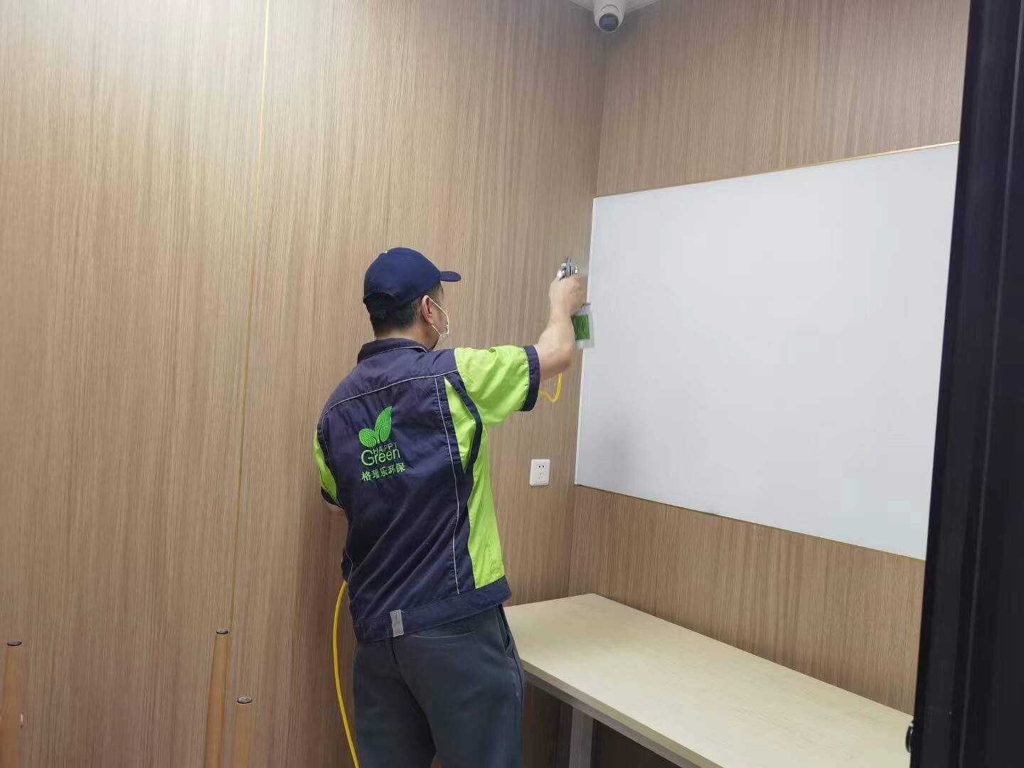 书房电脑桌的主机托上，工作人员粘贴格瑞乐除甲醛散热除醛贴纸。