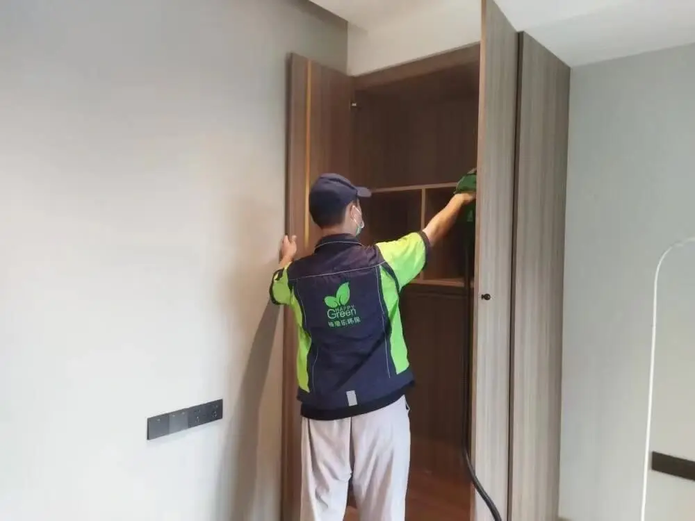 客厅电视背景墙的插座旁的木质装饰条上，工作人员涂抹格瑞乐除甲醛光触媒涂料，利用光线分解周边甲醛。