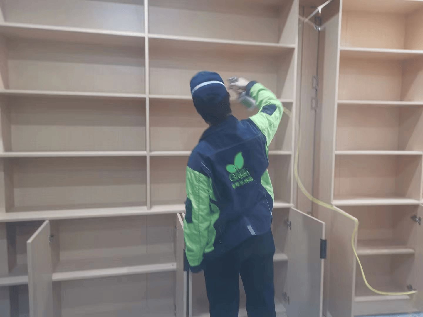 施工人员手中的格瑞乐除醛清洁布，浸润着除醛清洁剂，用于擦拭家具表面的甲醛污染物。