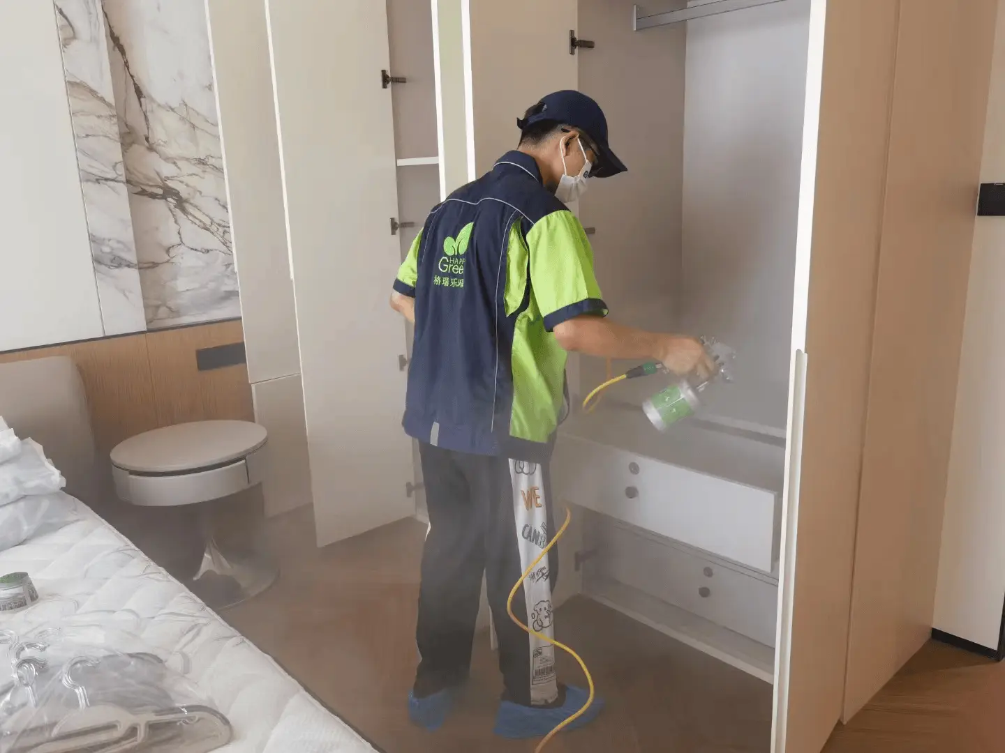 玄关处,施工人员对鞋柜内部进行重点除醛喷涂和擦拭,去除异味和甲醛。